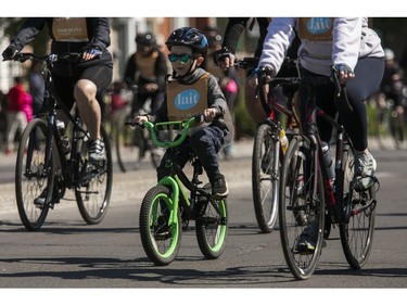 A youngster rides along Rosemont Blvd. during the 38th Tour de l'île de Montréal in Montreal on Sunday, June 4, 2023.