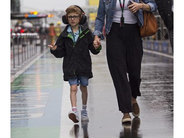Max Brunet walks along pit lane with his parents in the rain at Circuit Gilles Villeneuve prior to a practice and qualifying session for the Canadian Grand Prix on Saturday, June 17, 2023.