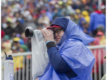 A Formula 1 fan takes photos in the rain at Circuit Gilles Villeneuve during a practice session for Canadian Grand Prix on Saturday, June 17, 2023.