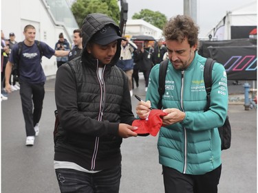 Two-time world champion Formula 1 driver Fernando Alonso, a driver for the Aston Martin Aramco Cognizant F1 team, signs an autograph for a fan as he arrives at Circuit Gilles Villeneuve for a practice and qualifying session for Canadian Grand Prix on Saturday, June 17, 2023.