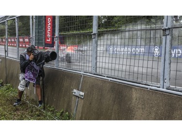 An Oracle Red Bull car creates spray in the rain as it speeds by a photographer at Circuit Gilles Villeneuve during a practice session for Canadian Grand Prix Saturday, June 17, 2023.