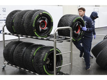 Scuderia Alphatauri team members clean and organize tires in the rain at Circuit Gilles Villeneuve during a practice/qualifying session for the Canadian Grand Prix on Saturday, June 17, 2023, in Montreal.