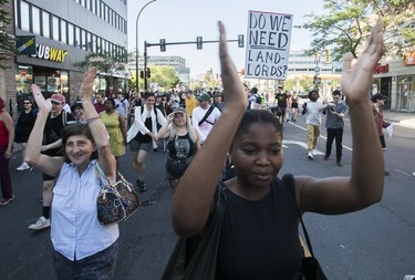 Protesters raise their hands to clap during a march