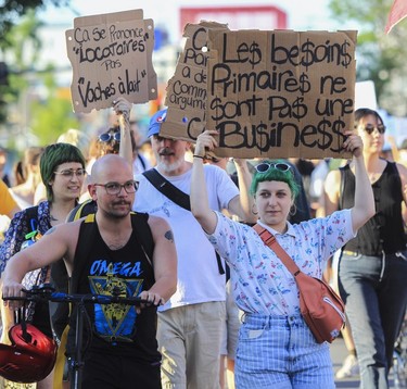 Marchers hold anti-landlord signs during a protest