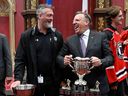 Premier François Legault, right, celebrates with Quebec Remparts general manager and coach Patrick Roy while holding the trophy during a ceremony on June 8 at the National Assembly marking the team's Memorial Cup win.