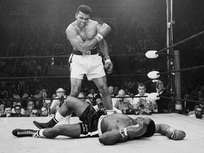 Muhammad Ali stands over Sonny Liston in the ring