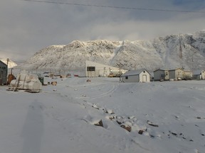 white buildings against a snowy mountain in nunavut
