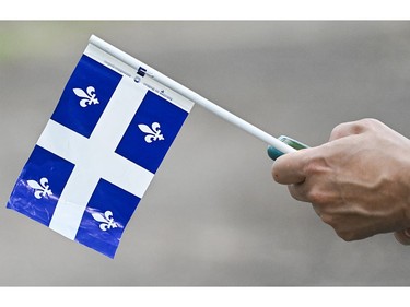 A person holds a Quebec flag on Saint-Jean-Baptiste day in Montreal on Saturday, June 24, 2023.