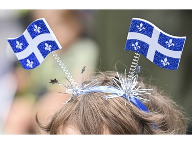 A young child wears Quebec flags on his head during Saint-Jean-Baptiste day in Montreal, Saturday, June 24, 2023.