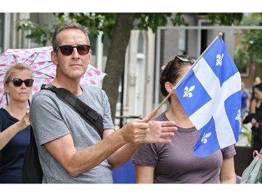 A man waves a Quebec flag on Saint-Jean-Baptiste day in Montreal, Saturday, June 24, 2023.