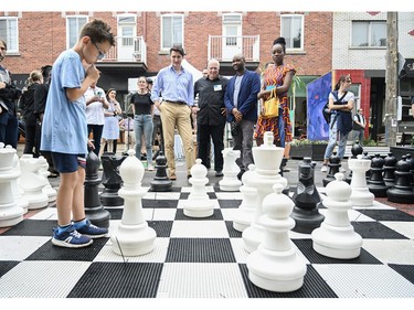 Prime Minister Justin Trudeau, fourth right, looks on as a young boy ponders his next chess move during an event on Saint-Jean-Baptiste in Montreal, Saturday, June 24, 2023.