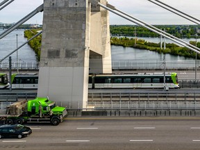 a green truck matches the green of an rem car on the champlain bridge