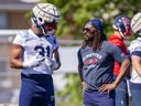 Running-backs coach Tyrell Sutton speaks with William Stanback during Alouettes training camp in Trois-Rivières in May.