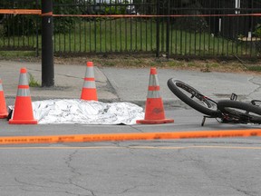 The body of cyclist struck by a truck is covered on the corner of Papineau Ave. and de Maisonneuve Blvd. on Tuesday July 4, 2023. The truck did not stop at the scene.