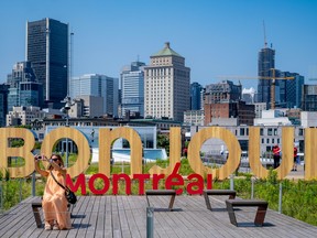 woman takes a selfie in front of a large bonjour montreal installation