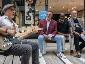 Jim Beis, Errol Johnson and Philippe Voisard listen to Deacon George playing at Fairview Mall in Pointe-Claire on Friday, June 30, 2023.