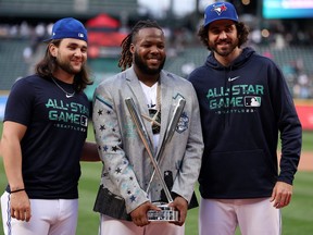 Vladimir Guerrero Jr. (centre) stands with Toronto Blue Jays teammates Bo Bichette (left) and Jordan Romano after winning the Home Run Derby.