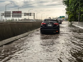 Cars drive through a shallow flood on a highway on-ramp