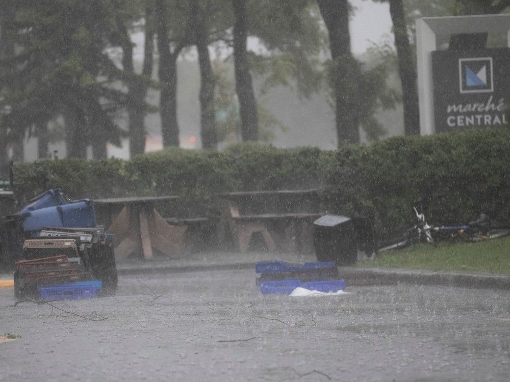 Plastic crates litter a parking lot in the rain