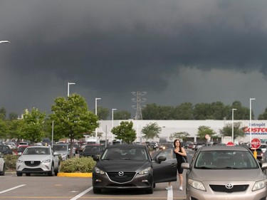 Dark storm clouds rise in the background of a parking lot
