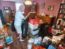 Peter Shea looks through boxes from his basement stacked in his dining room after flooding from last week's storm.