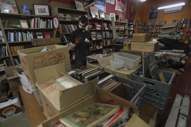 Photo of a man filling boxes with books in a bookstore