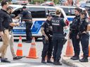 Montreal police officers and investigators at the scene where one of their colleagues was stabbed in the Côte-des-Neiges district of Montreal on Wednesday, July 26, 2023.