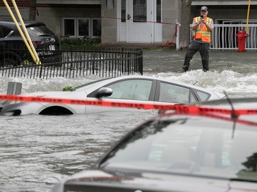 a city worker photographs submerged cars after flooding