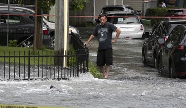 a resident looks forlornly at flooded street in st-michel