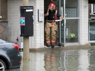 a firefighter looks at rising water after water main break