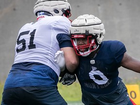 Alouettes defensive-end Shawn Lemon pulls away from guard Kristian Matte during practice.
