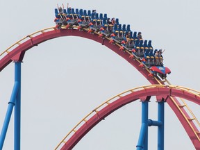 People wear face masks as they ride 'The Goliath',