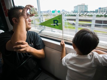 People look out the window of an REM train on the Ssouth Shore of Montreal on Saturday July, 29, 2023.