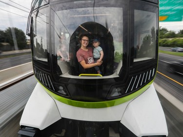 Marie-Pier Lessard holds her son James as they look out the window of an REM train on the South Shore near Montreal on Saturday July, 29, 2023.