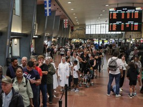 Long lines of people wait for an REM train at Central Station in Montreal on Saturday, July, 29, 2023, during an open house ahead of the official start of the automated light rail service on Monday.