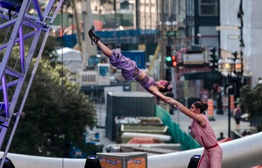 A man swings an acrobat into the air