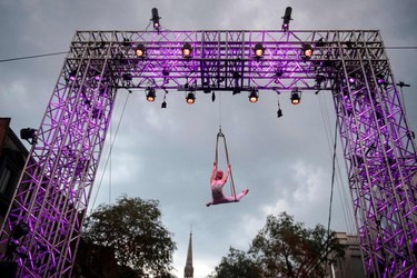 An acrobat swings from. structure during a street performance