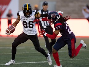 Alouettes' Dionté Ruffin defends Tiger-Cats wide-receiver Jon'Vea Johnson.