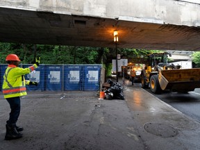 Front loaders along a street under a highway