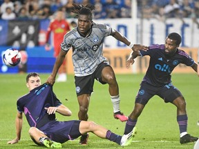 CF Montréal's Chinonso Offor, centre, is challenged by Charlotte FC's Jan Sobocinski, left, and Nathan Byrne during second half MLS soccer action in Montreal on Saturday, July 15, 2023.