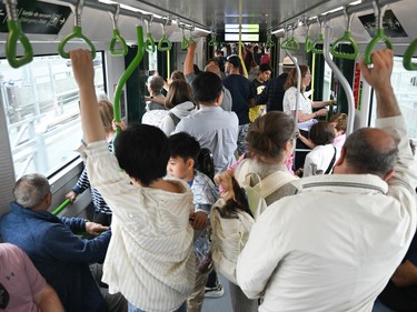 People take a ride on the REM light rail system in Montreal on Saturday, July 29, 2023.
