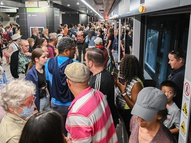 People enter and exit a REM light rail train at Central Station in Montreal on Saturday, July 29, 2023.