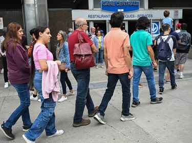 People wait in line to take a free ride on REM light rail system in Montreal on Saturday, July 29, 2023. The REM opens Monday to fare paying passengers.