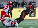 Alouettes running-back William Stanback is tackled by Stampeders' Kobe Williams Sunday night at Molson Stadium.