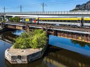 A Via Rail Canada Inc. train passes over the Lachine Canal at the Peel Basin toward downtown Montreal.