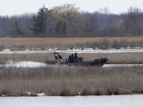 A police boat searches in the Mohawk Territory in Akwesasne on Friday, March 31, 2023. The Akwesasne Mohawk Police Service says it has recovered the body of a man who is connected to the investigation into the deaths of eight migrants.