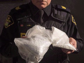 An OPP officer displays bags containing fentanyl as Ontario Provincial Police host a news conference in Vaughan, Ont., on February 23, 2017.