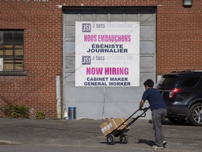 A "Now Hiring" sign is displayed on a business in Montreal
