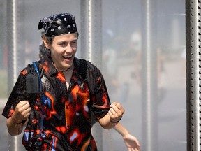 a person laughs as they walk through a misting station