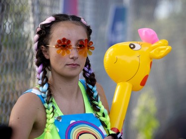 A woman with colourful braids in flower sunglasses with an inflatable giraffa